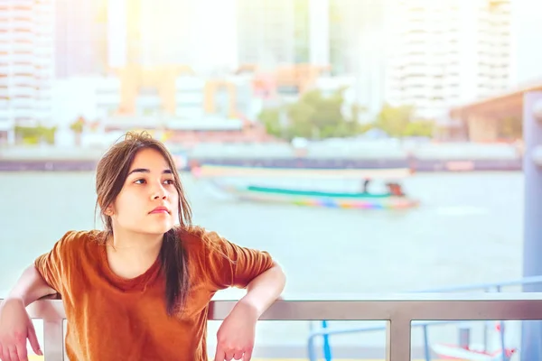 Menina adolescente bonita inclinando-se sobre trilhos à beira do rio — Fotografia de Stock