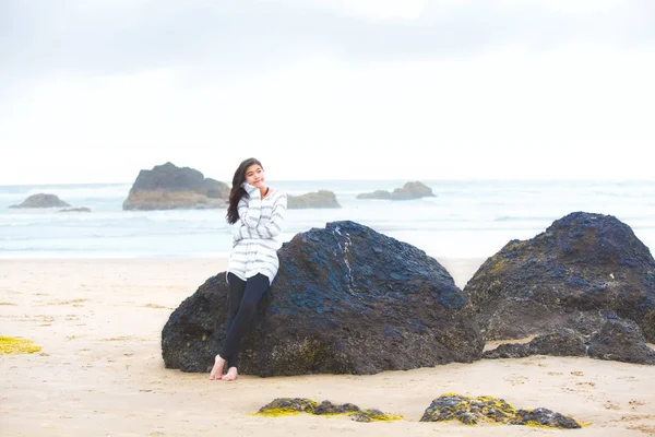 Junges Teenie-Mädchen lehnt an großen Felsen am Meer und denkt — Stockfoto