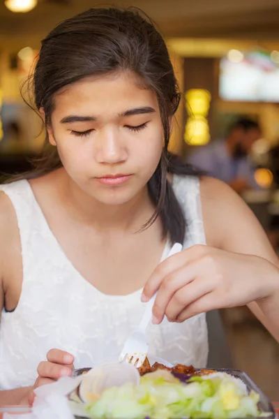 Biracial teen girl eating salad at restaurant — Stock Photo, Image