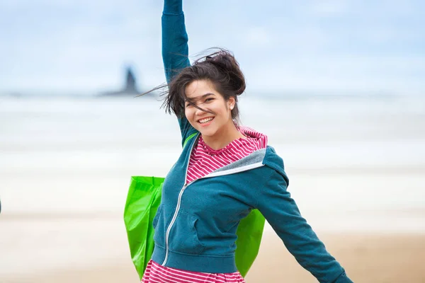Szczęśliwa dziewczyna w niebieski płaszcz, na plaży, rozpostartymi ramionami — Zdjęcie stockowe