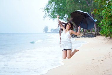 Plajda şemsiye yağmur zevk tutan beyaz elbiseli kadın 