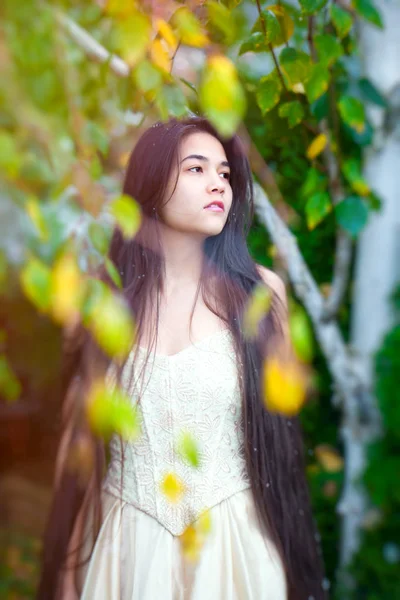 Młoda kobieta w złota sukienka na zewnątrz pod brzoza — Zdjęcie stockowe