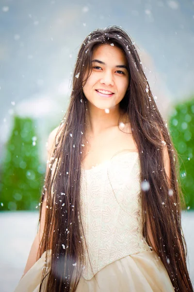 Biracial joven mujer en vestido de oro en el día nevado, sonriendo —  Fotos de Stock