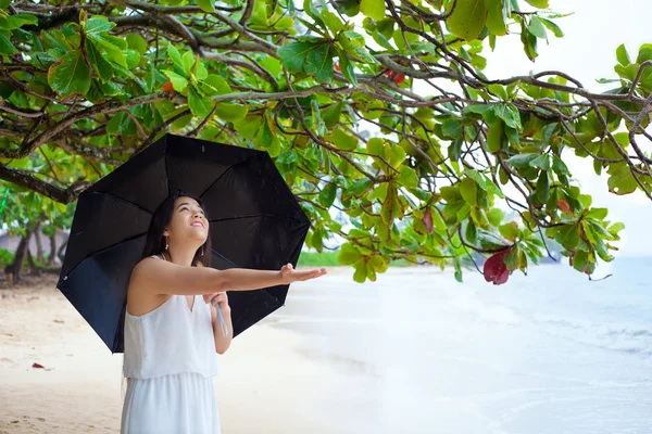 雨の中で傘を持ってハワイのビーチで若い女性 — ストック写真