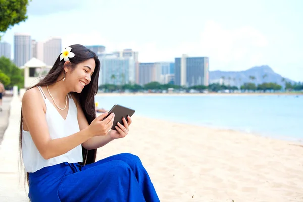 Biracial teen girl sur la plage à l'aide d'un ordinateur tablette, Waikiki, Hono — Photo