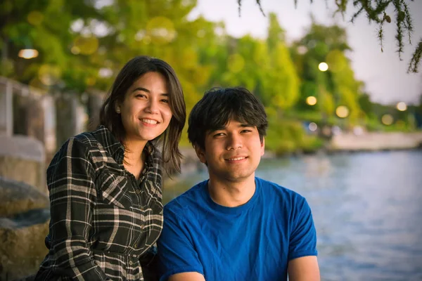 Young biracial Asian Caucasian young people by lake at sunset — Stok fotoğraf