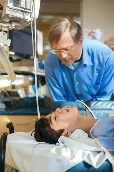 Padre vigilando a su hijo inconsciente en la sala de recuperación del hospital — Foto de Stock