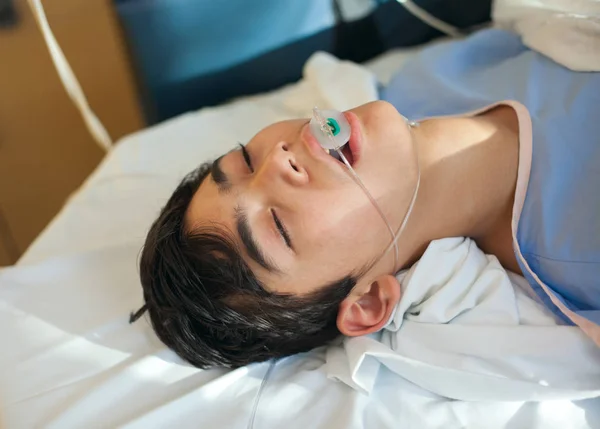 Мальчик-подросток без сознания в больничной палате на каталке — стоковое фото