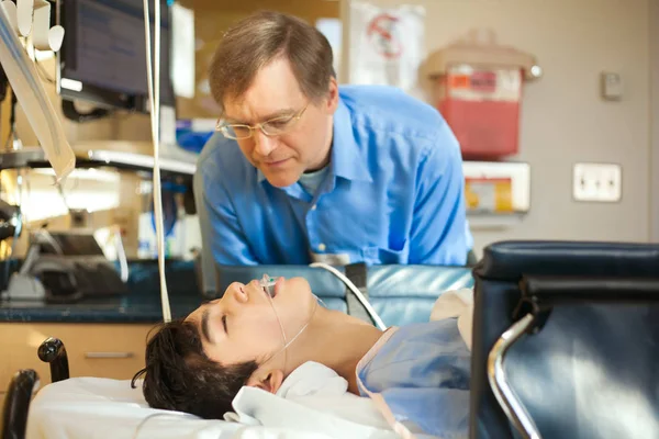 Padre vigilando a su hijo inconsciente en la sala de recuperación del hospital — Foto de Stock