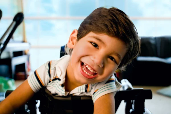 Feliz sorrindo biracial deficiente menino em pé no walker — Fotografia de Stock