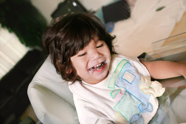 Biracial Discapacitado pequeño niño sentado en silla de ruedas sonriendo — Foto de Stock