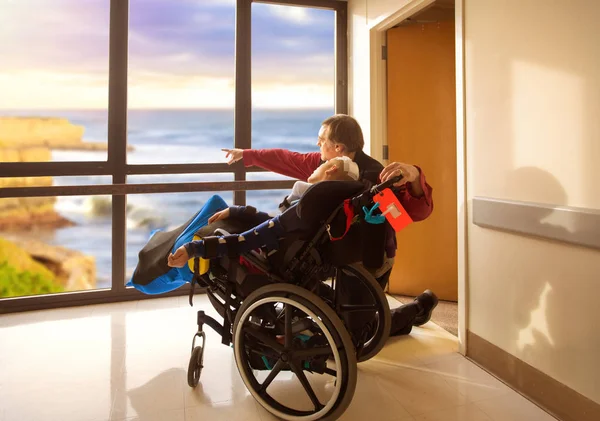 Father with disabled son after surgery looking out hospital wind — 스톡 사진