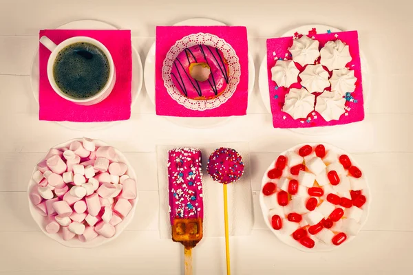 Doces coloridos e marshmallow com xícara de café na mesa de madeira branca. Vista superior — Fotografia de Stock