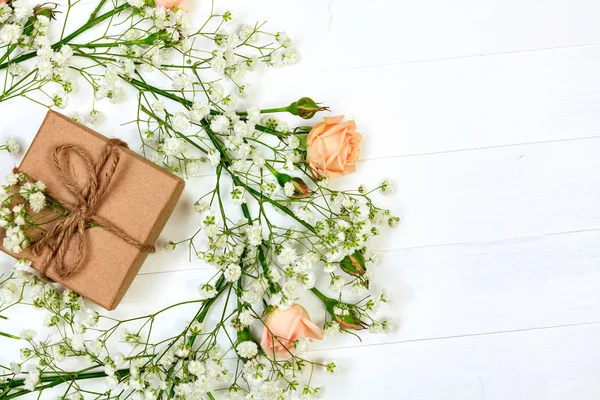 Цветы с подарочной коробкой на белом деревянном столе, плоский стиль — стоковое фото