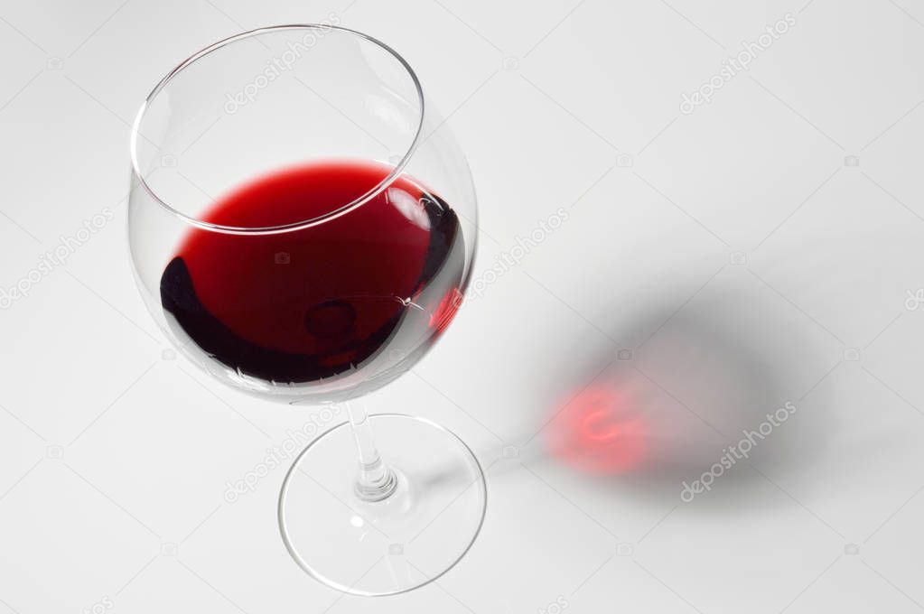 Wineglass with red wine.