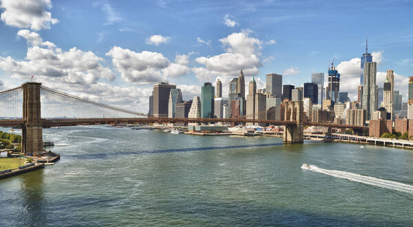 Manhattan skyline with Brooklyn Bridge at sunny day.