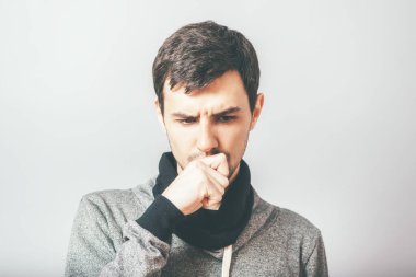 Adam fotoğraf stüdyosunda öksürüyor.