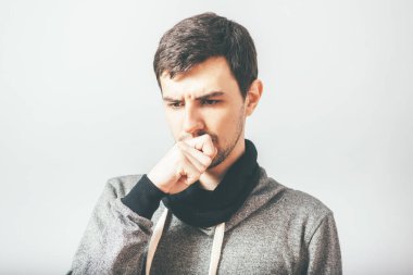 Adam fotoğraf stüdyosunda öksürüyor.