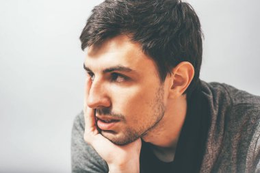 Adam çenesini elinde tutuyor.