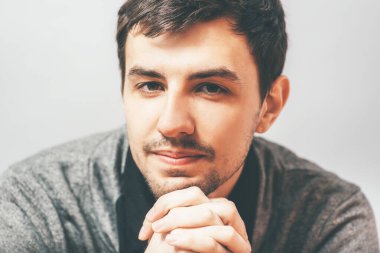 Çenesi elleri olan bir adamın portresi.