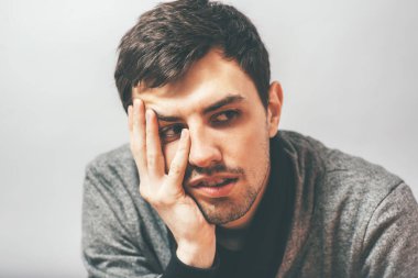 Adam çenesini elinde tutuyor.