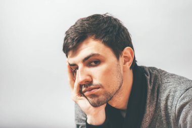 Adam çenesini elinde tutuyor.