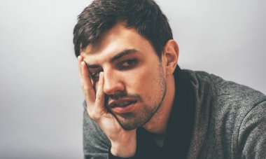 Adam çenesini elinde tutuyor.