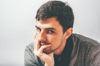 Adam çenesini elinde tutuyor.