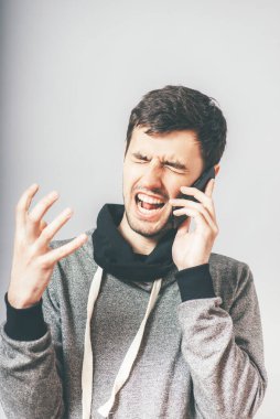 Sinirli iş adamı cep telefonuyla bağırıyor, beyaz arka planda izole edilmiş genç yakışıklı iş adamının portresi, yönetici bağırması kavramı, iletişim sorunu iletişim krizi