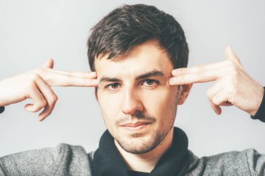 Adam ellerini şakaklarına koydu.