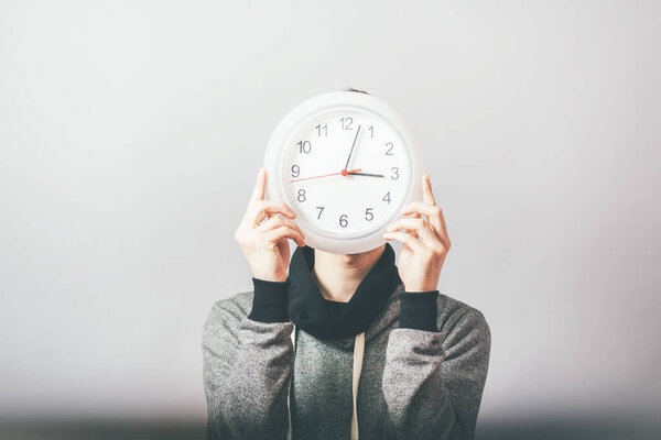 Бизнесмен держит большие часы
