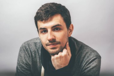 Adam çenesini yumruğuyla destekledi.