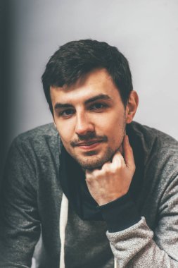 Adam çenesini yumruğuyla destekledi.