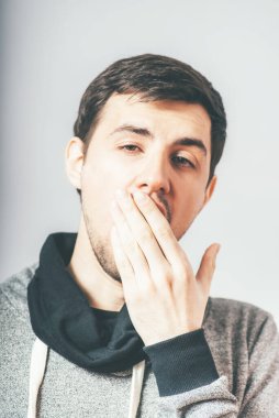 Fotoğraf stüdyosunun arka planında esneyen genç adam