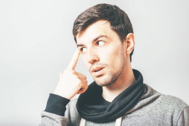 Adam parmağını şakağına dayıyor.