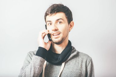 Adam cep telefonuyla konuşuyor.