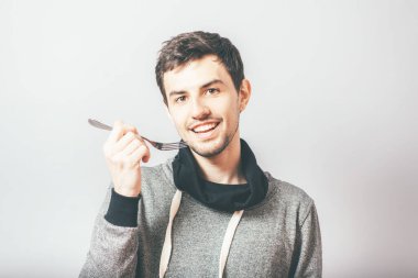 Çatalla yemek yiyen bir adam.