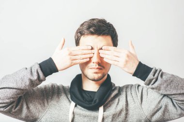 Adam elleriyle gözlerini kapatıyor.