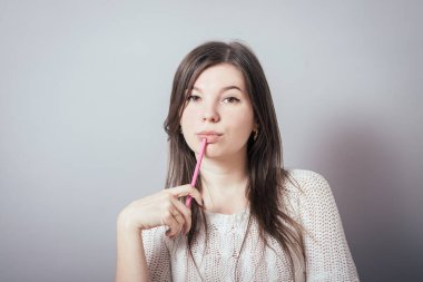 Gri arka planda poz veren kız