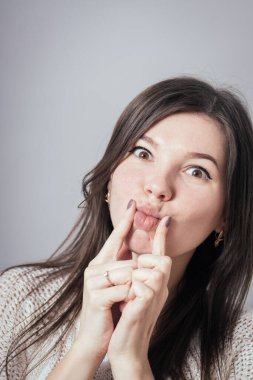 Gri arka planda poz veren kız