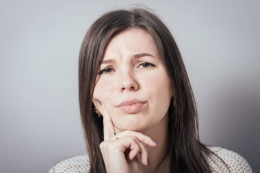 Gri arka planda düşünen kız