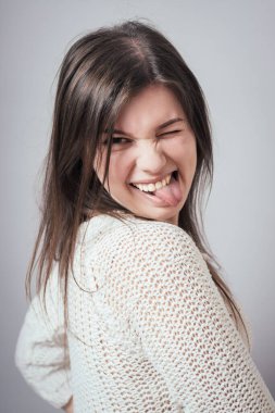 Kız gri arka planda dil gösteriyor