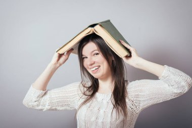 Arkasında üniversite binası olan güzel bir öğrencinin portresi. Kitapları elinde tutuyor..