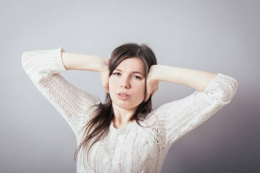 Kız elleriyle kulaklarını kapatıyor.