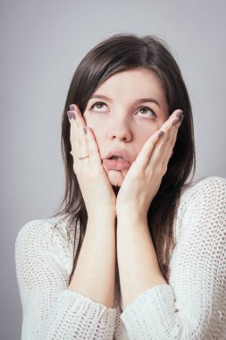 Gri arka planda şokta olan kadın