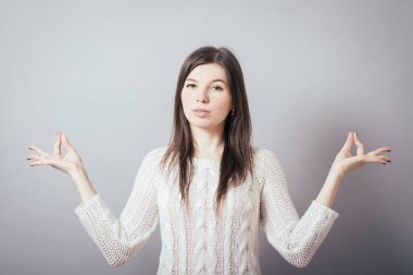 Kız gri arka plan üzerine meditasyon yapıyor.