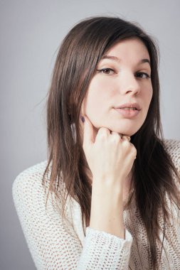 Kız çenesini yumruğuyla destekliyor.