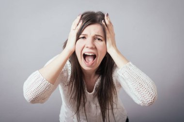 Kız çığlık atıyor, başını tutuyor.