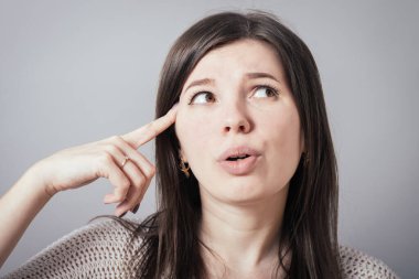 Gri arka planda düşünen kız