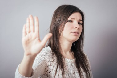 Gri arkaplanda kız duruşu gösterir